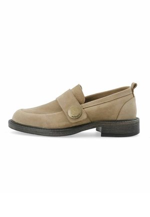 Mocassin en daim beige avec une semelle noire, un petit talon et une large bride ornée d'un bouton logo métallique rond sur le côté.