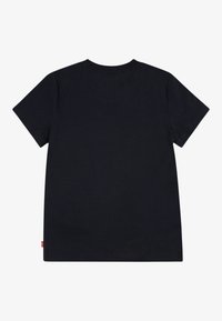 Lühikeste varrukatega T-särk tumesinisest puuvillast, millel on klassikaline ümmargune kaelus ja väike punane logo silt alumisel vasakul küljel.