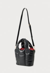 Saco de couro preto com um design macio e fofy, duas alças superiores e uma alça destacável. O interior apresenta um padrão vibrante em vermelho. Acessórios em dourado.
