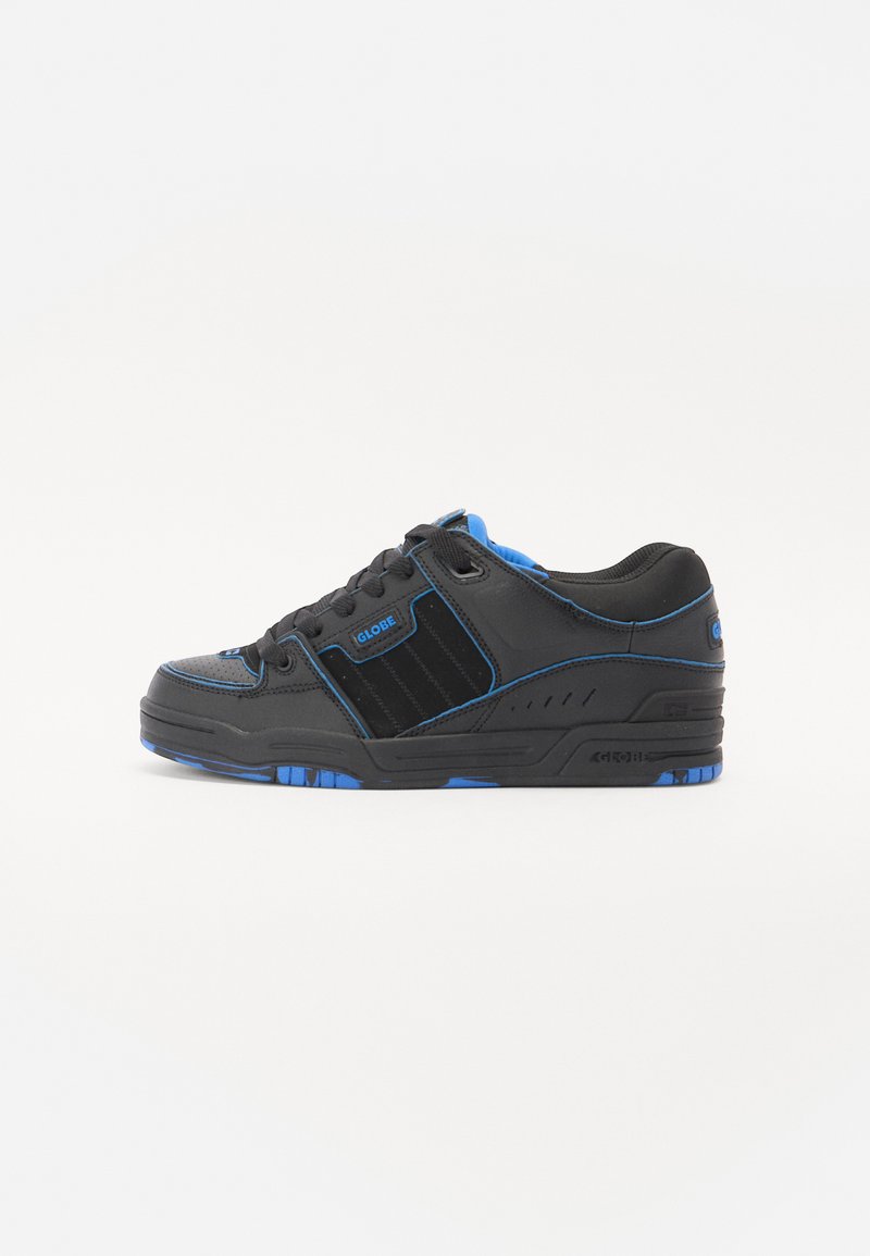 Tenis pretos com detalhes azuis, materiais em couro e têxteis, bico redondo, painéis texturizados e sola de borracha preta com desgaste azul.
