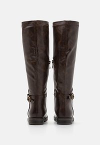 Braune Lederstiefel bis zum Knie mit glatter Textur, ausgestattet mit einem seitlichen Reißverschluss und einem verstellbaren Riemen mit dekorativer Schnalle.