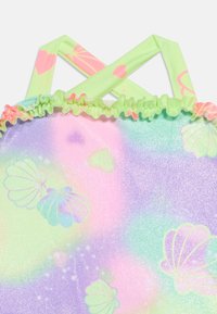 Λαμπερό παστέλ μαγιό με σχέδια από θαλασσινά κοχύλια και ανοιχτοπράσινα λουράκια που διασταυρώνονται στην πλάτη με ροζ καρδιές και αστέρια.