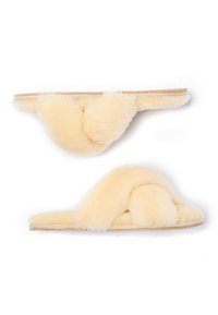Cream-colored fluffy slippers featuring a twisted design, soft texture, and a flat sole, suitable for indoor use.