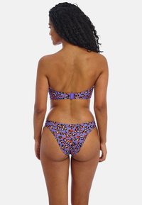 Bikini-setti violettissä, jossa on leopardikuosiset yksityiskohdat. Siinä on olkaimeton yläosa ja matalavyötäröiset alaosat, joissa on saumaton muotoilu.