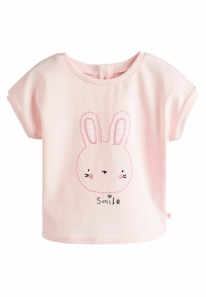 Roza bombažna majica s kratkimi rokavi, ki ima vezenino zajčjega obraza in besedilo "Smile" v črni barvi. Okrogla izrezana zasnova, mehak material.