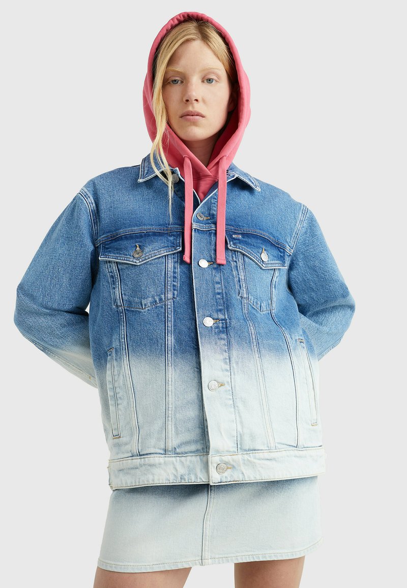 Denim jacket ombre disainiga, tumedast heledaks siniseks kahandav, millel on kaks rinna taskut, hõbedane riistvara, kantud roosa kapuutsiga.