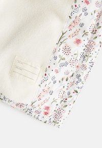 Fleece blanket featuring a floral-patterned border with muted colors and a sewn-in fabric label for customization.