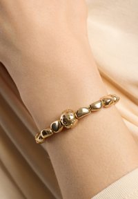 Bracelet en or avec des perles rondes et polies, orné d'un charm sphérique décoratif orné de pierres précieuses colorées.