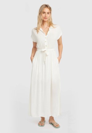 Witte maxi-jurk met korte mouwen, een knoopsluiting aan de voorkant en een ceintuur in de taille. Voorzien van zijzakken en een lichte textuur.