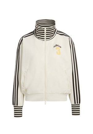 Bílá bunda na zip s vysokým límcem, černé pruhované detaily na rukávech a límci, s číslem 3 a zlatým logem "adidas".