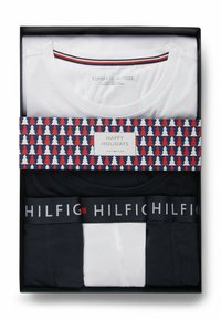 Σετ λευκά και μαύρα T-shirts και εσώρουχα Tommy Hilfiger σε κουτί με κορδέλα με θεματικό χριστουγεννιάτικο μοτίβο που λέει Ευτυχισμένες Γιορτές.