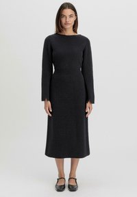 Langärmliges, geripptes Strickkleid in Dunkelgrau, mit einem Boot-Ausschnitt und einer taillierten Taille, die bis zur Midi-Länge reicht. Strukturierter Stoff.