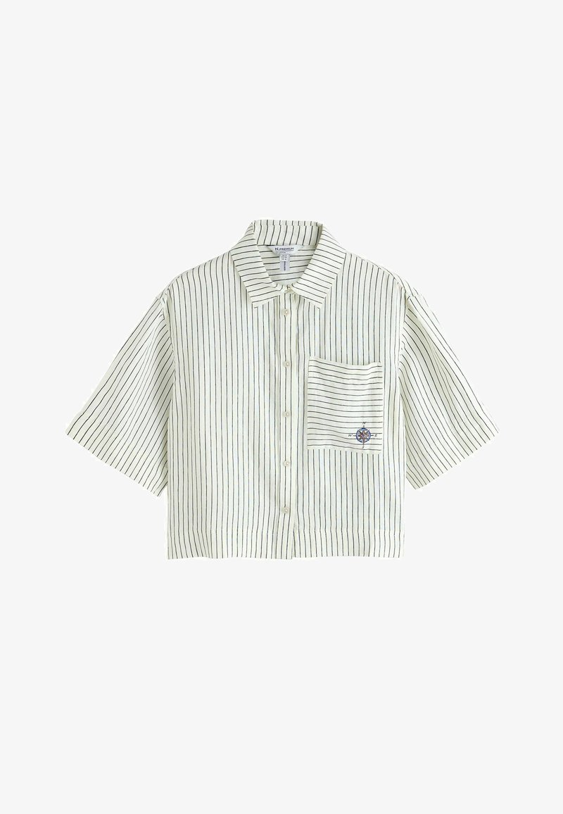 Chemisier court à manches courtes, blanc avec de fines rayures verticales noires, boutons à l'avant, col, et une poche ornée d'un petit emblème de boussole.