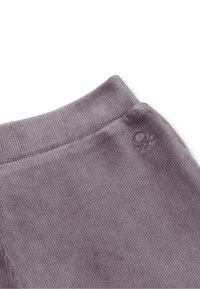 Fialová kordová látka s jemnou texturou, s malou vyšívanou značkou na pásku. Design je jednoduchý a funkční.