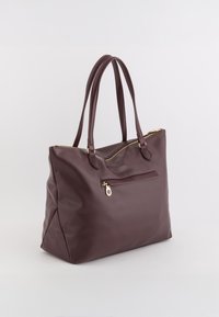 Brązowa skórzana torba na ramię z dwoma uchwytami, zamkiem błyskawicznym na górze i zewnętrzną kieszenią. Gładka tekstura i minimalistyczny design. Akcenty w kolorze złotym.