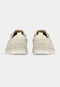 Λευκά αθλητικά παπούτσια με απαλό επάνω μέρος από σουέντ και δίχτυ, επίπεδη σόλα και μινιμαλιστικό σχεδιασμό. Διαθέτουν διακριτικό λογότυπο και υφασμένα διακοσμητικά στοιχεία στη φτέρνα.