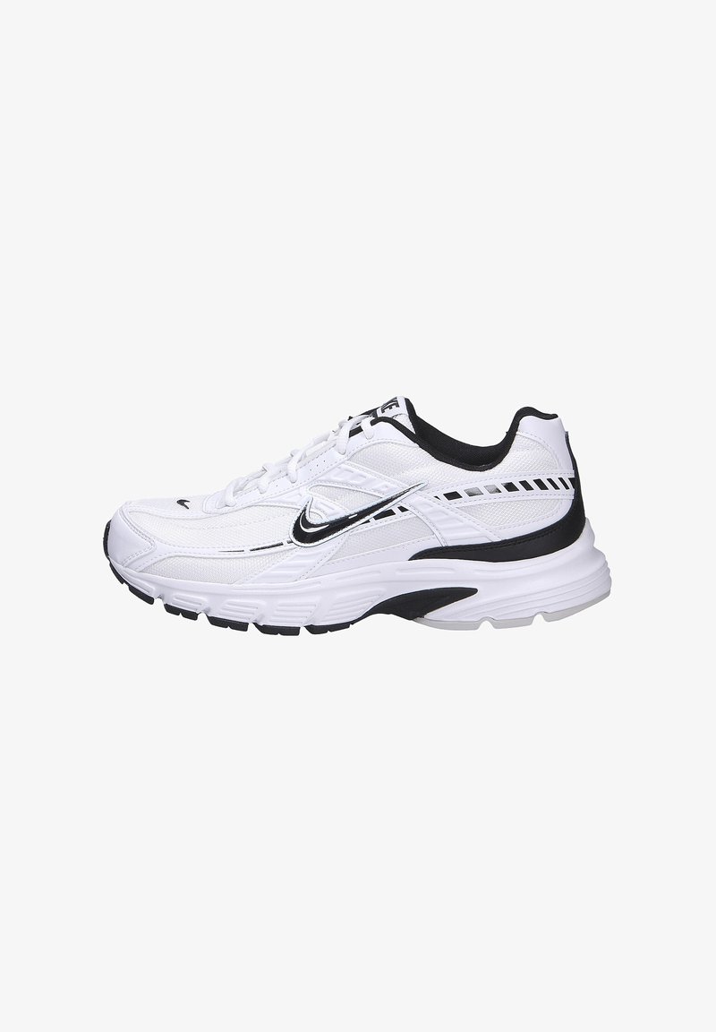 Zapatilla deportiva blanca con acentos negros, parte superior de malla, cordones y suela de goma, con un logotipo de Nike plateado y un detalle con patrón en los lados.