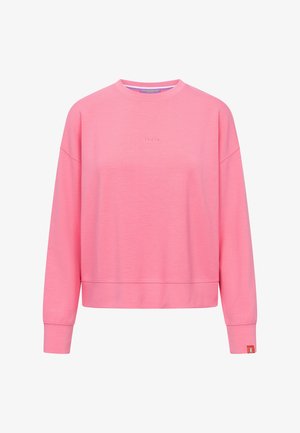 Roze sweatshirt met lange mouwen en ronde hals, met "Frieda" in reliëf op de borst en een klein oranje label aan de linkermouw.