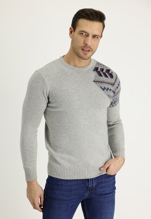 Suéter de punto gris con cuello redondo, puños acanalados y un patrón geométrico en tonos de marino y burdeos en un hombro.