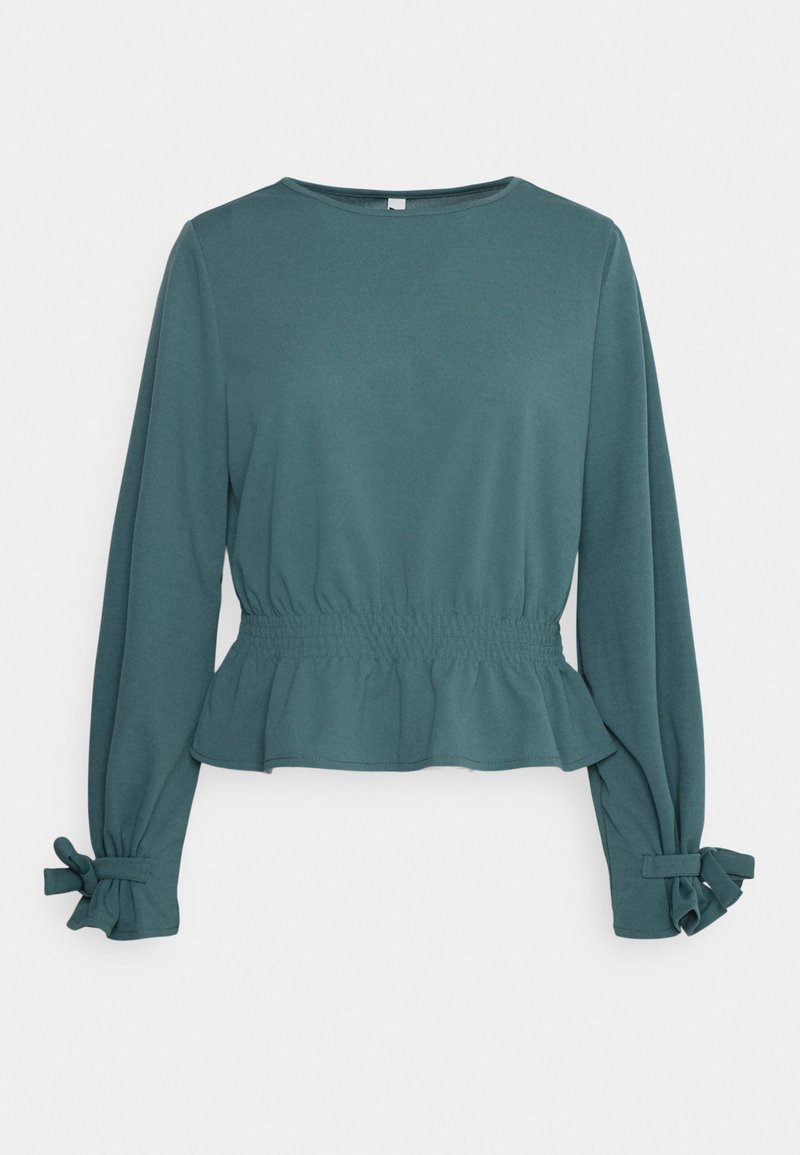 Τυρκουάζ μπλούζα με μακριά μανίκια και στρογγυλή λαιμόκοψη, με ελαστική μέση και μανσέτες με ρυάκια που διαθέτουν φιόγκους. Λείο ύφασμα με χαλαρή εφαρμογή.