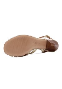 Heel sandal with a gold metallic upper and adjustable ankle strap. Rubber sole with horizontal grooves for traction. Smooth wood-like heel.