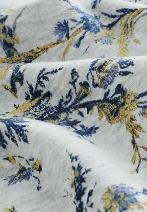 White fabric with a floral pattern in blue and gold, featuring intricate designs. Soft texture with visible weave and color contrast.