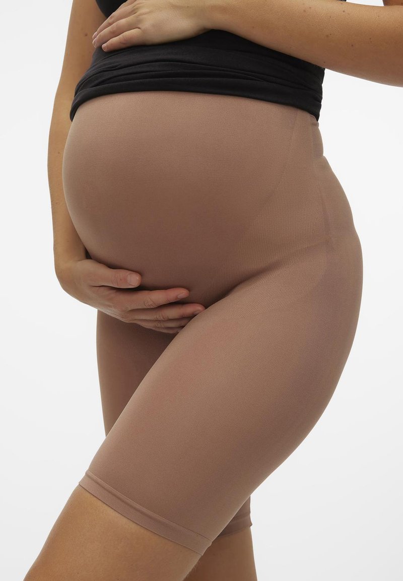 Graviditetsshorts i en lys brun farge, laget av elastisk stoff, med elastisk midje og design som går til kneet, tilpasset rundt magen.