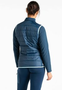 Marineblaue isolierte Jacke mit gesteppten Einsätzen, die an den Ärmeln eine weiche Fleece-Oberfläche und einen kontrastierenden hellblauen Besatz aufweist.