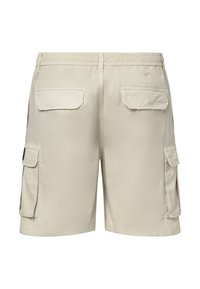 Shorts cargo beige avec taille élastique, deux poches à rabat à l'arrière et poches à rabat sur les deux jambes.