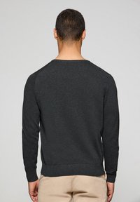 Sudadera gris oscuro de manga larga, con puños y dobladillo acanalados, hecha de tejido texturizado, que presenta un cuello redondo y sin logotipos visibles.