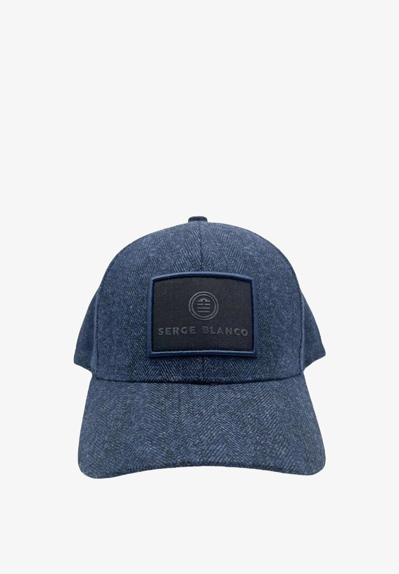 Casquette bleu foncé en motif chevron avec un patch rectangulaire noir affichant un logo circulaire et le texte "Serge Blanco" à l'avant.