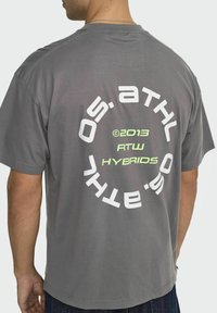 Graues Baumwoll-T-Shirt mit einem großen kreisförmigen Grafikdesign in Weiß und Neon-Grün auf dem Rücken, mit zentral bedrucktem Markentext und Jahr.