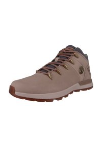 Jasnoróżowe buty trekkingowe za kostkę z brązowymi oczkami i sznurówkami, teksturowana zamszowa cholewka oraz kontrastowa brązowa gumowa podeszwa. Logo drzewa po bokach.