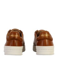 Sneaker in pelle marrone con suole bianche, caratterizzati da una forma arrotondata e un logo impresso sul tallone posteriore. Texture liscia, design minimale.