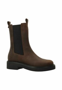 Botte Chelsea en cuir marron avec des panneaux élastiques noirs sur les côtés, des languettes de tirage et une épaisse semelle en caoutchouc noir.
