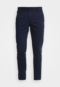 Pantalon ajusté bleu marine en coton avec une taille plate, des poches latérales et une texture lisse. Pas de motifs visibles ni de détails en métal.