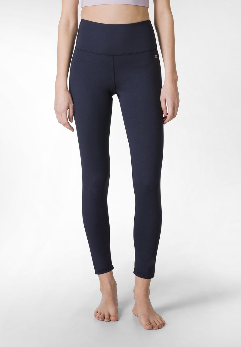 Leggings a vita alta blu navy realizzati in materiale elasticizzato con una texture liscia, dotati di un sottile accento con logo vicino alla vita.