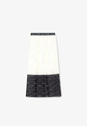 Jupe plissée avec un schéma de couleurs noir et blanc. La partie supérieure est blanche, tandis que le bas présente un design noir texturé avec des reflets scintillants.