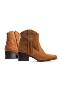 Stivaletti alla caviglia in camoscio beige con punta appuntita e tacco basso a blocco. Presentano dettagli a frange e una cerniera laterale per facilitare la calzata.