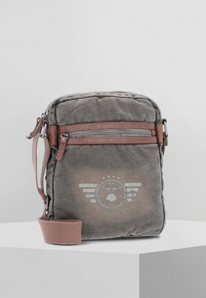 Gray fabric crossbody bag with a textured finish, brown accents, two zippers, and a circular logo design on the front. Adjustable strap included.