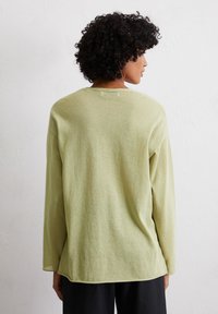 Camicia a maniche lunghe di colore verde chiaro realizzata in un tessuto morbido e testurizzato. Presenta un colletto rotondo e una vestibilità comoda con orlo curvo.