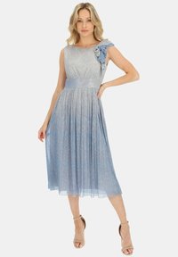 Jasnoniebieska sukienka do kolan o teksturowanym metalicznym wykończeniu. Jeden ramiączko ozdobione jest falbanami, a szeroki satynowy pasek dopełnia całość.