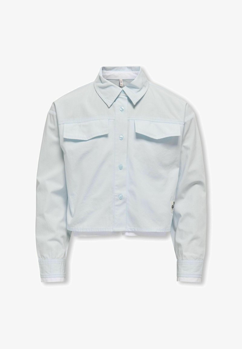 Helles blaues Crop-Shirt mit Knopfleiste, klassischem Kragen und zwei Brusttaschen. Der Stoff wirkt glatt und leicht.