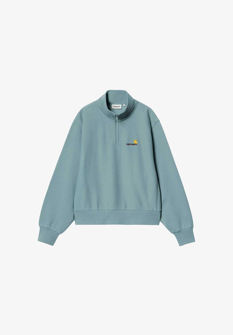 Sudadera de azul claro con cremallera en el cuello, de mangas largas, puños y dobladillo acanalados, y pequeño logotipo amarillo bordado en el lado izquierdo del pecho.