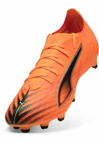 Scarpino da calcio arancione brillante con tomaia strutturata, accenti neri e design aerodinamico. Presenta una tradizionale chiusura con lacci e tacchetti modellati.