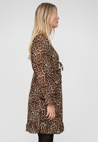 Kleid mit Leopardenmuster, das lange Ärmel, eine taillierte Taille mit einem Bindeband, einen gerafften Saum und eine fließende Stofftextur aufweist.