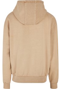 Beige kapucnis pulóver bordázott mandzsetta és aljjal, puha szövettextúrával és egyszerű, laza dizájnnal, elülső részletek nélkül.