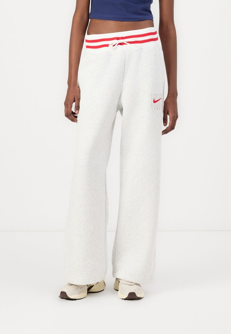 Light gray sweatpants with a wide-leg design, red and white striped waistband, and a small red Nike logo on the left side.