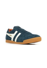 Baskets en suede bleu foncé avec des rayures blanches et le logo Gola. Elles disposent d'une semelle en gomme texturée et d'une doublure intérieure orange. Design à lacets.