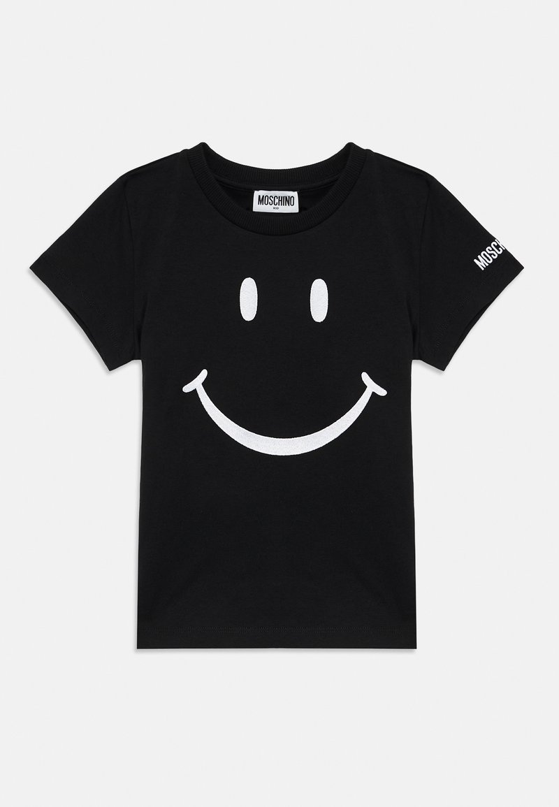 T-shirt de algodão preto com uma grande estampa de um rosto sorridente branco na parte da frente. Nome da marca "Moschino" impresso na manga.